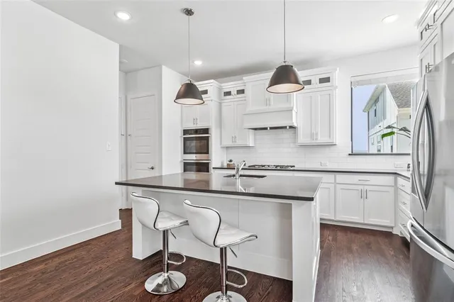 a kitchen with stainless steel appliances granite countertop a sink and a stove