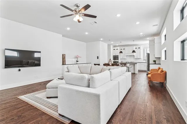 a living room with furniture a ceiling fan and a rug