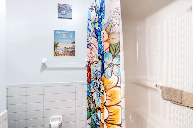 a kitchen with stainless steel appliances granite countertop a refrigerator a sink dishwasher a stove and a dining table with wooden floor