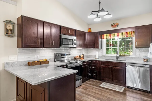 a living room with furniture a fireplace and a floor to ceiling window