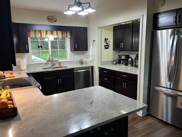 a kitchen with a sink refrigerator and cabinets
