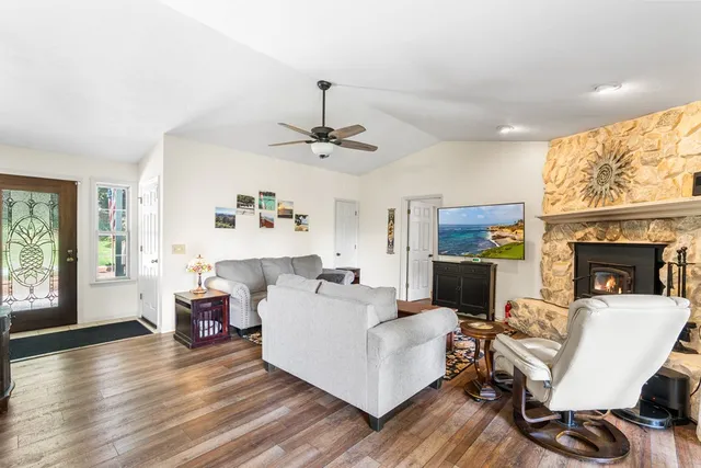 a view of backyard with seating space and trees in the background
