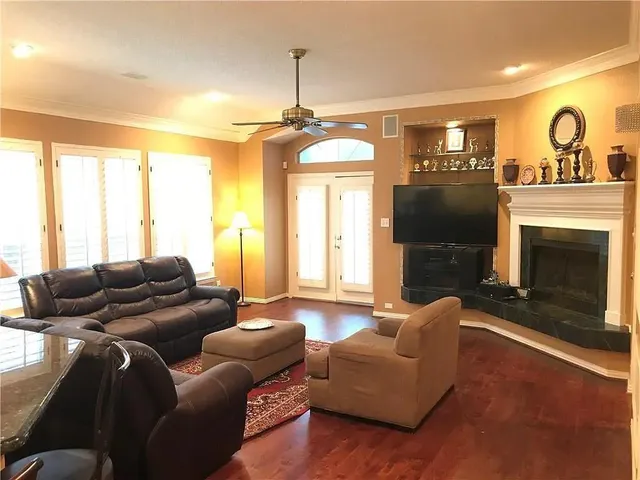 a bed sitting in a bedroom next to a window with wooden floor