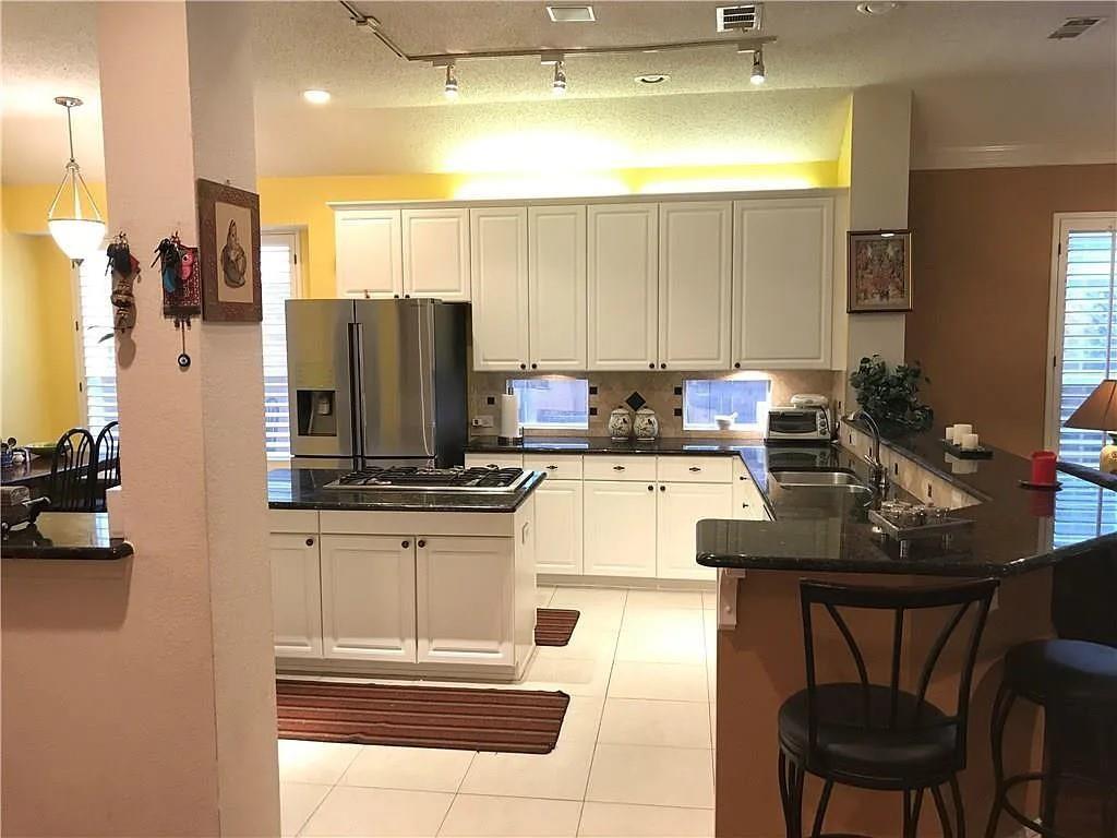 9400 Western Trail Irving, TX 75063 - Photo 22 of 24 a kitchen with stainless steel appliances kitchen island granite countertop a sink and cabinets