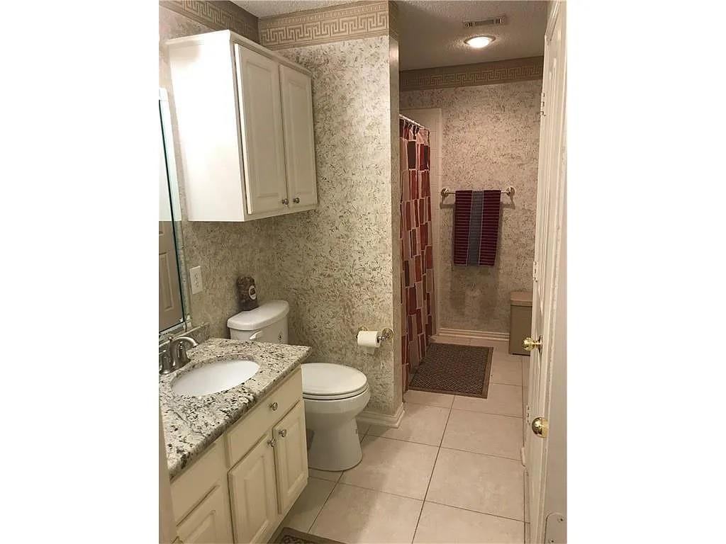 9400 Western Trail Irving, TX 75063 - Photo 5 of 24 a bathroom with a granite countertop sink toilet and shower