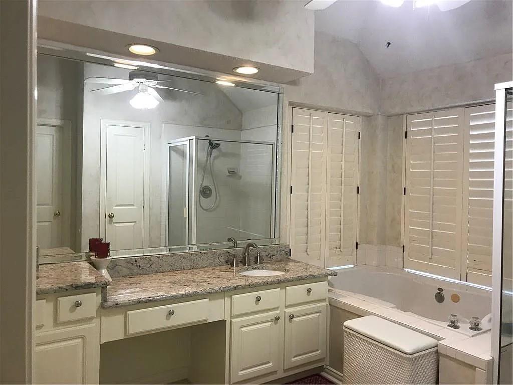 9400 Western Trail Irving, TX 75063 - Photo 6 of 24 a bathroom with a granite countertop sink a toilet a large mirror and shower