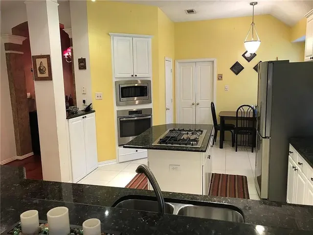 a kitchen with a refrigerator and a stove top oven
