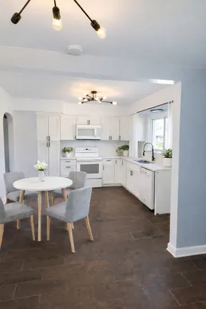 a kitchen with a sink cabinets and dining table chair