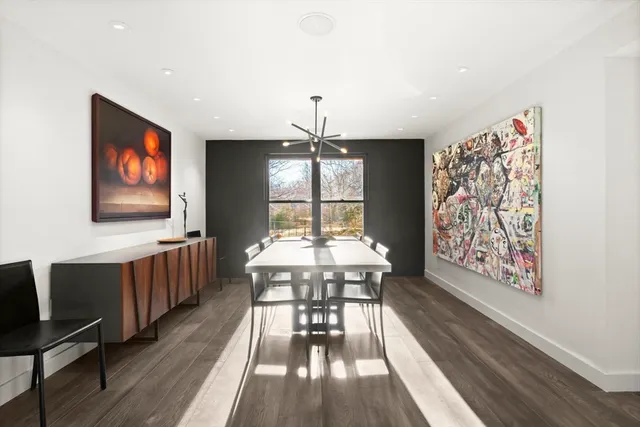 a dining room with wooden floor and large windows