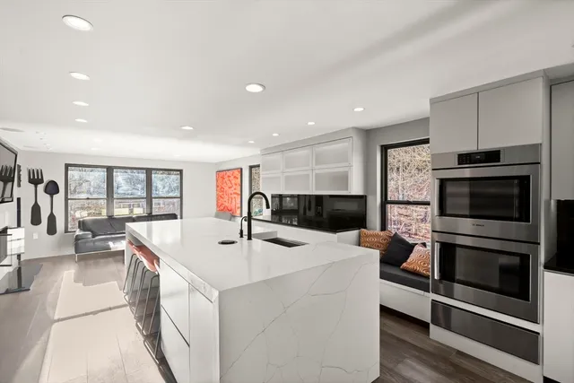 a kitchen with stainless steel appliances kitchen island granite countertop a refrigerator and a sink