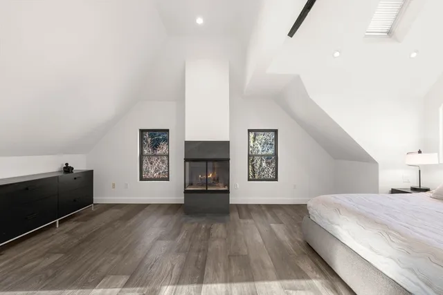 a spacious bedroom with a bed and a night stand