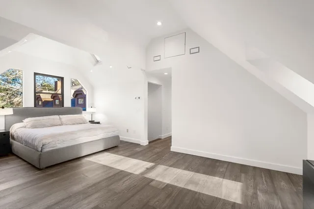 a spacious bedroom with a bed and a night stand