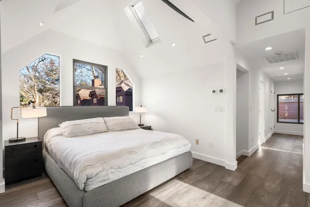 a bedroom with a large bed and a painting on the wall