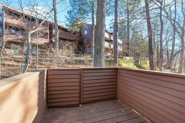 a view of a wooden house with a large window and wooden fence