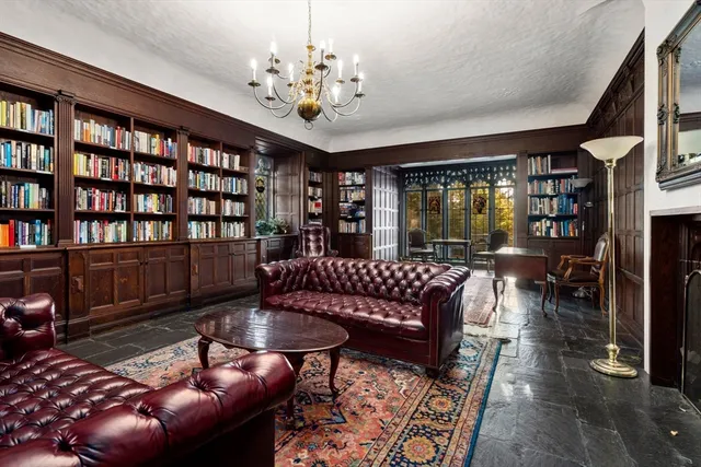 a living room with furniture a bookshelf and a chandelier