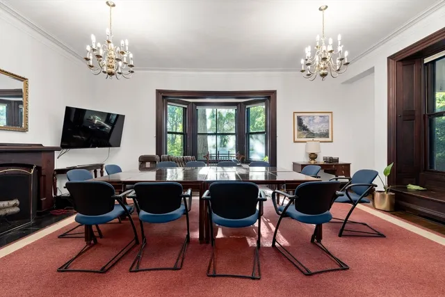 a view of a dining room with furniture a chandelier and window