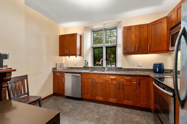 a kitchen with stainless steel appliances granite countertop a sink stove and microwave