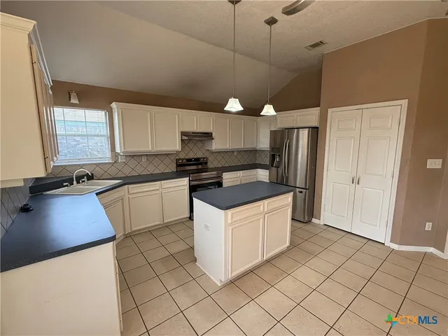 a kitchen with a stove a sink and a refrigerator