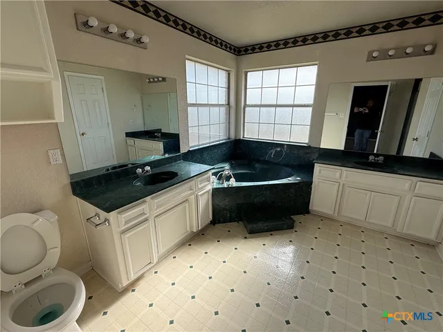 a kitchen with a sink a stove a microwave cabinets and a window