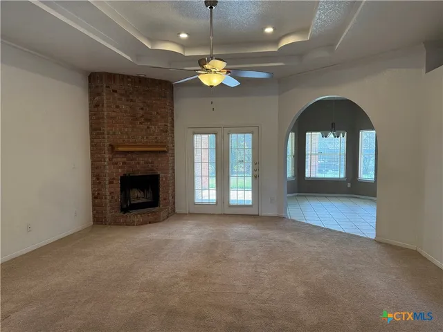 a view of a livingroom with a fireplace and chandelier fan