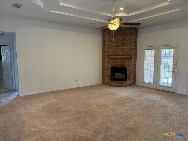 a view of empty room with fireplace and fan