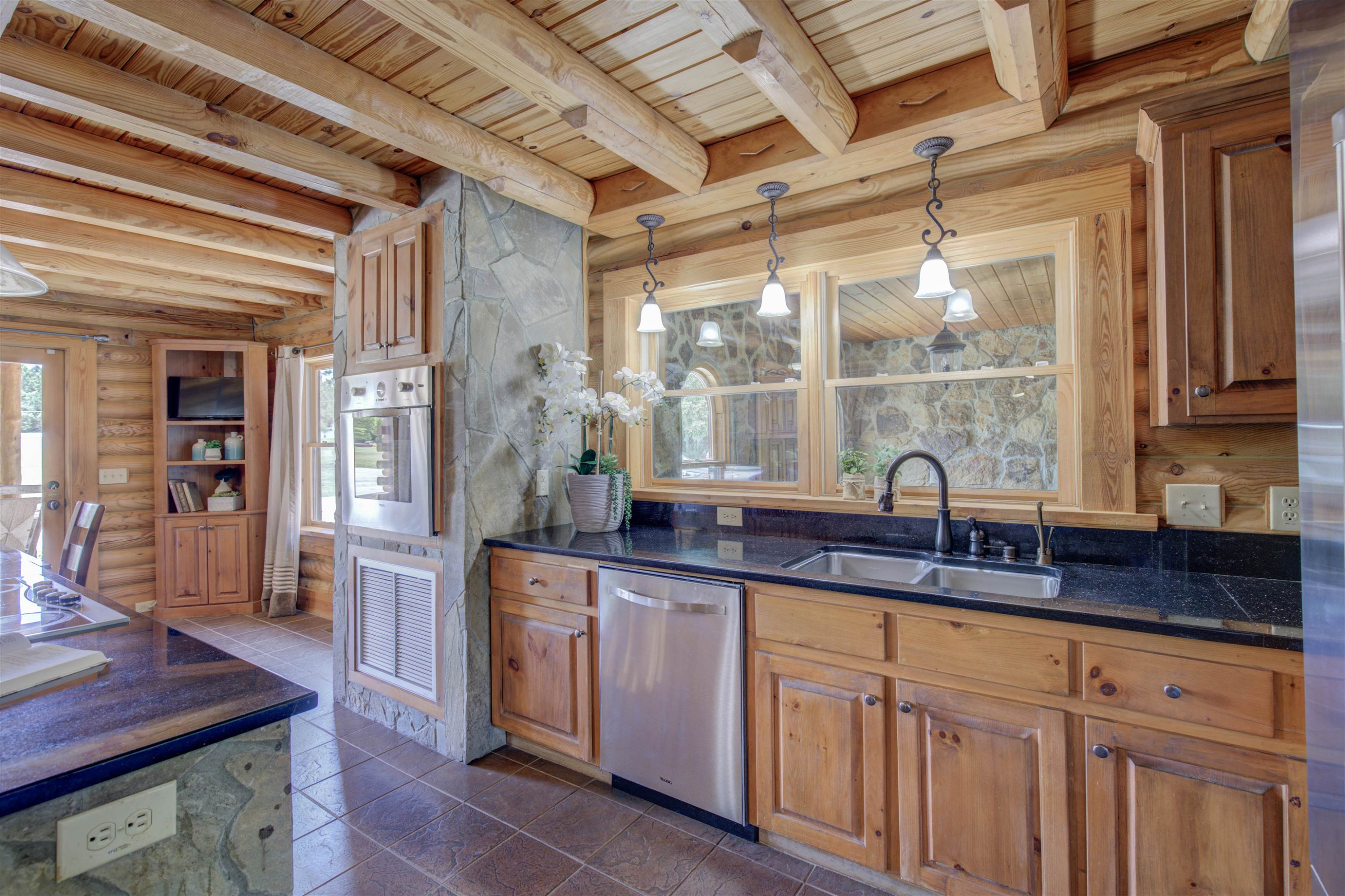 1039 North Chavis Road Kittrell, NC 27544 - Photo 19 of 53 a kitchen with granite countertop a sink stainless steel appliances wooden floor and a counter top space