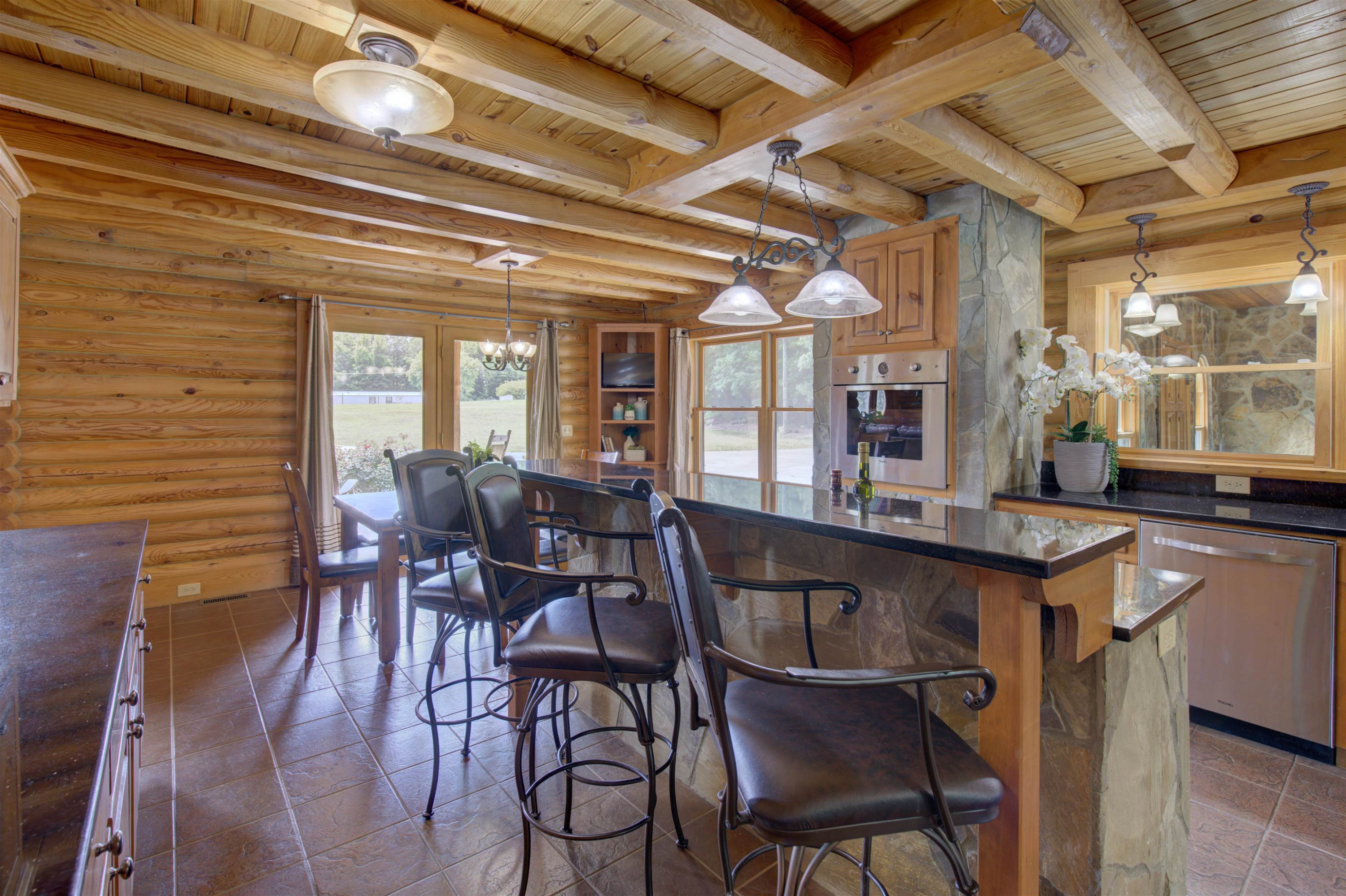 1039 North Chavis Road Kittrell, NC 27544 - Photo 42 of 53 a dining hall with stainless steel appliances granite countertop a dining table and chairs with wooden floor