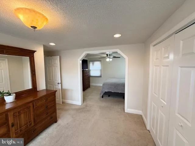 a view of a hallway to a livingroom and a bathroom