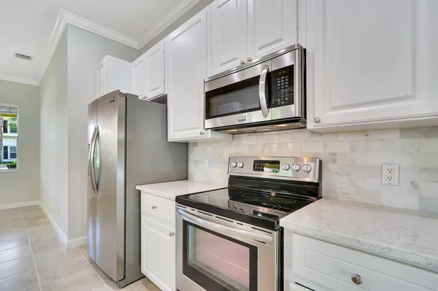 a kitchen with stainless steel appliances granite countertop a refrigerator a stove and a sink