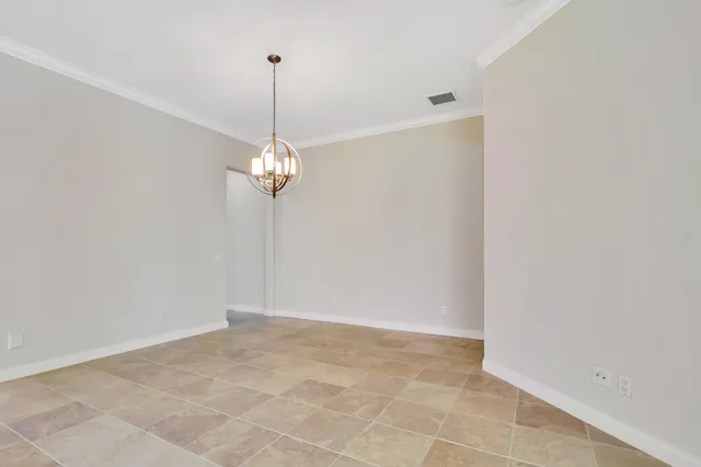 a view of an empty room with a chandelier fan