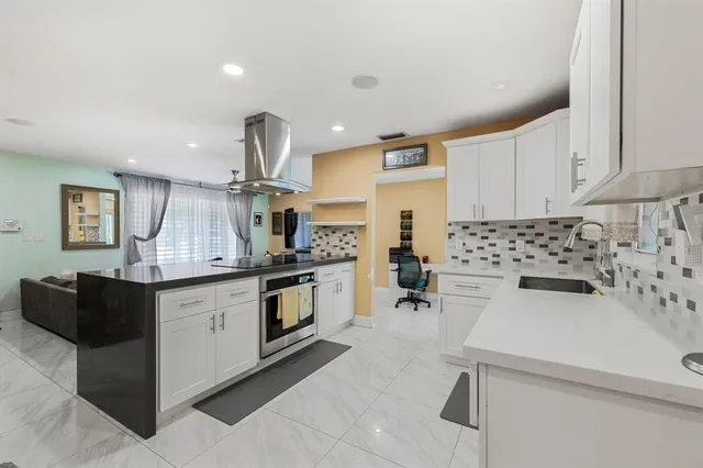 a kitchen with white cabinets and appliances