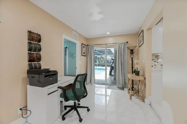 a view of a workspace with furniture and a window