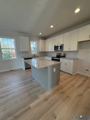 a kitchen with granite countertop a stove top oven sink and cabinets