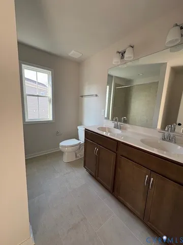 a bathroom with a double vanity sink a toilet and a mirror