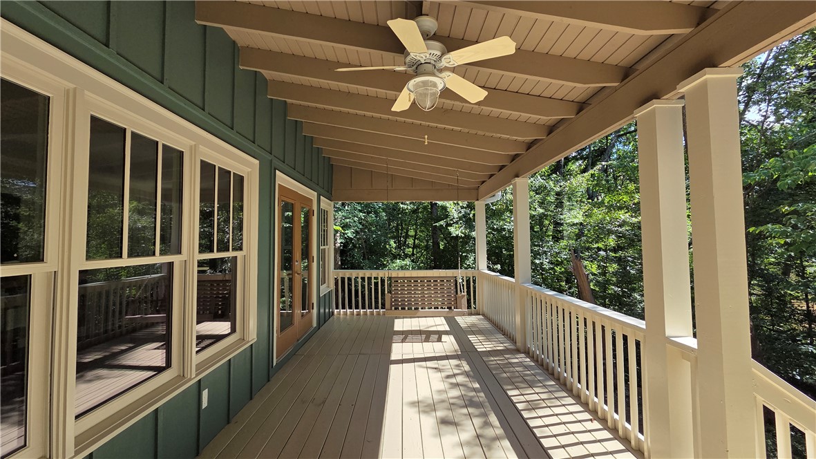 517 Chimney Ridge Westminster, SC 29693 - Photo 5 of 32 A spacious covered porch offers a tranquil retreat amidst the surrounding trees, complete with a porch swing and a ceiling fan.