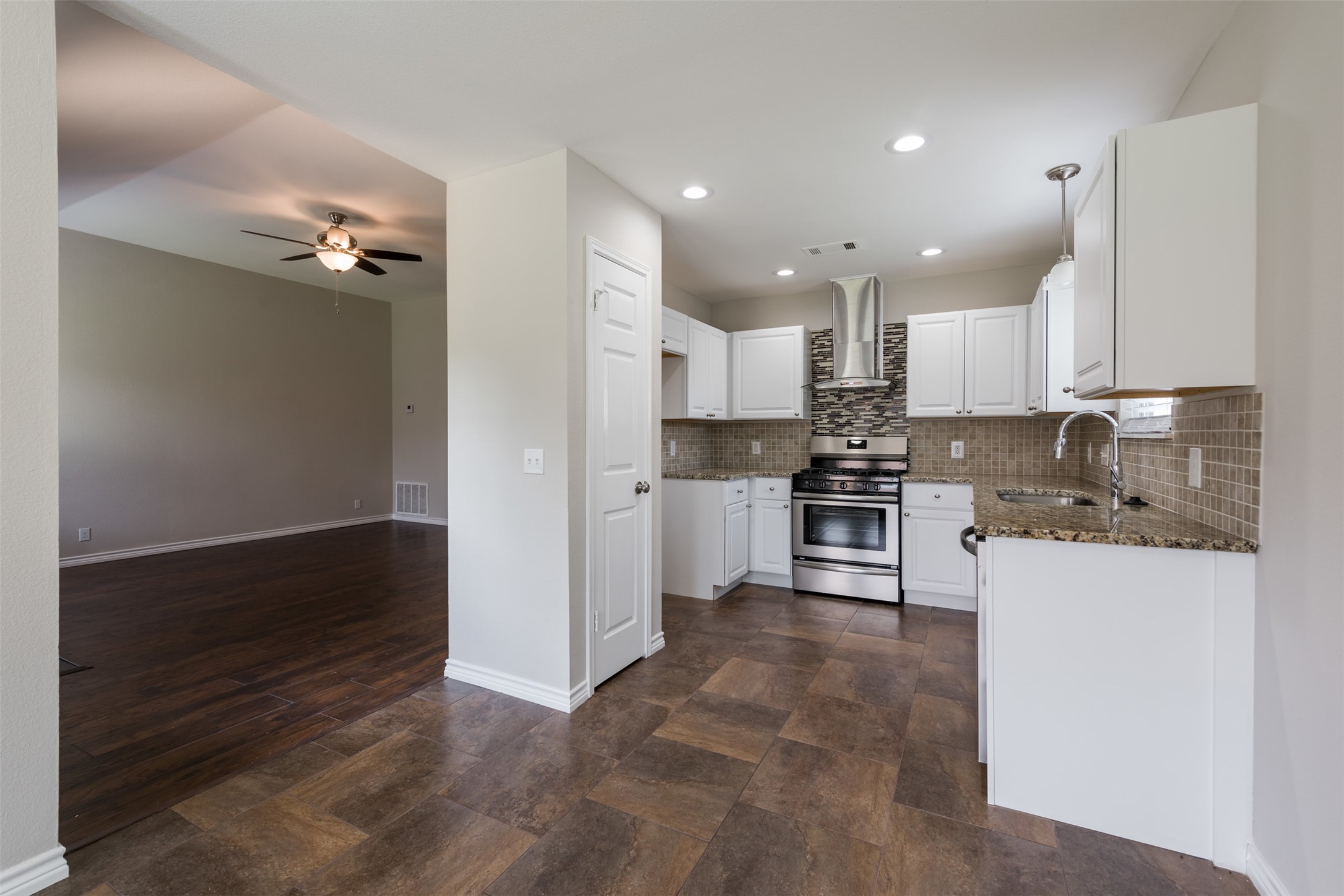 5703 Teri Road Austin, TX 78744 - Photo 8 of 16 a kitchen with granite countertop white cabinets and stainless steel appliances