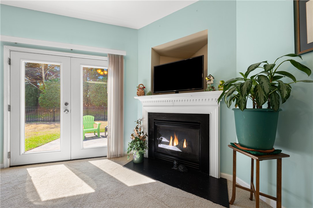 105 Ledgewood Way Easley, SC 29642 - Photo 6 of 35 This living space offers a warm fireplace and seamless access to the outdoor area.