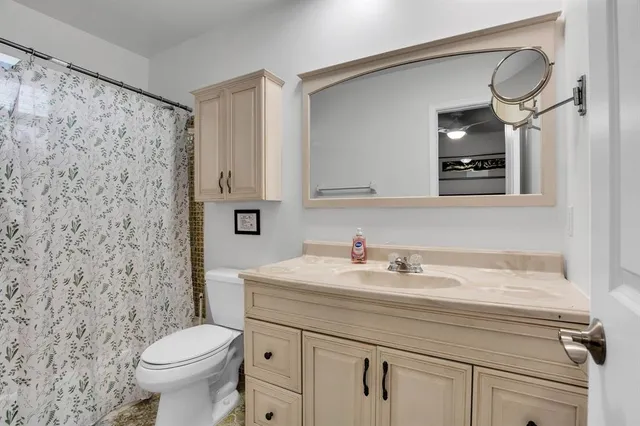 a bathroom with a sink toilet vanity and shower