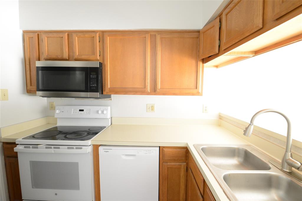 501 Arbor Creek Drive, Unit 204 Euless, TX 76039 - Photo 11 of 22 a kitchen with a sink a stove and a microwave
