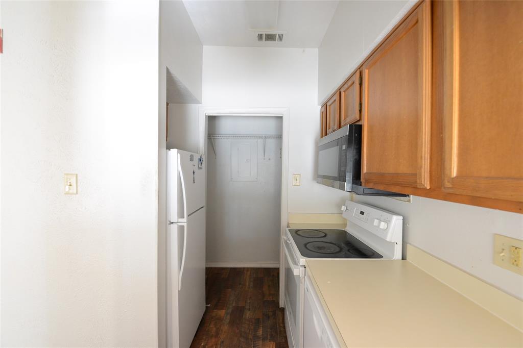 501 Arbor Creek Drive, Unit 204 Euless, TX 76039 - Photo 13 of 22 a kitchen with stainless steel appliances granite countertop a refrigerator a stove and a sink with wooden floor