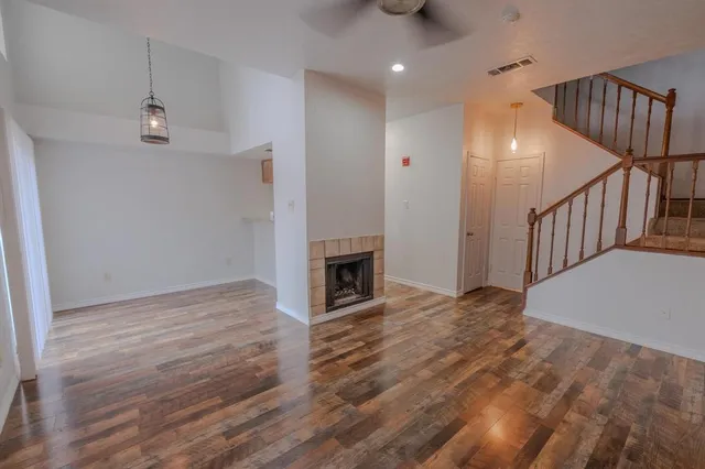 a view of empty room with wooden floor and fireplace