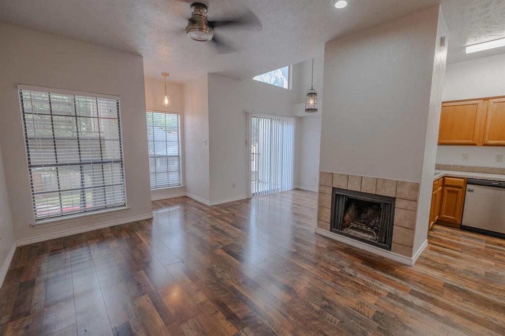 501 Arbor Creek Drive, Unit 204 Euless, TX 76039 - Photo 7 of 22 an empty room with wooden floor fireplace and windows