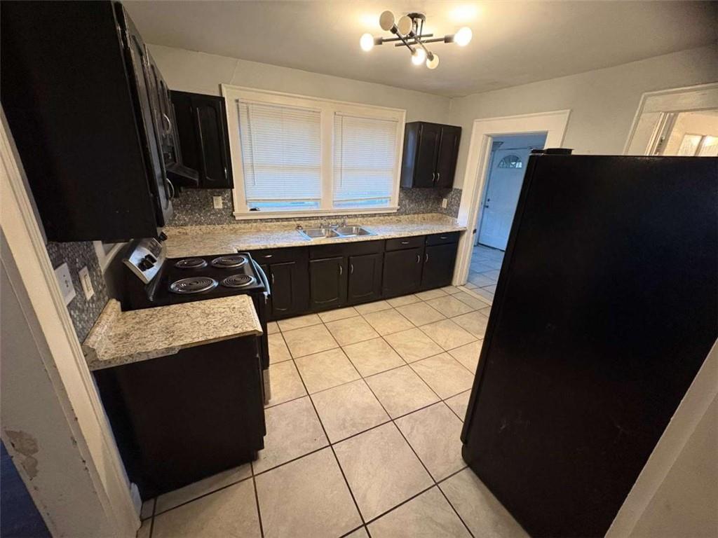 2421 Fairburn Road Southwest Atlanta, GA 30331 - Photo 12 of 15 a kitchen with granite countertop white cabinets and black appliances