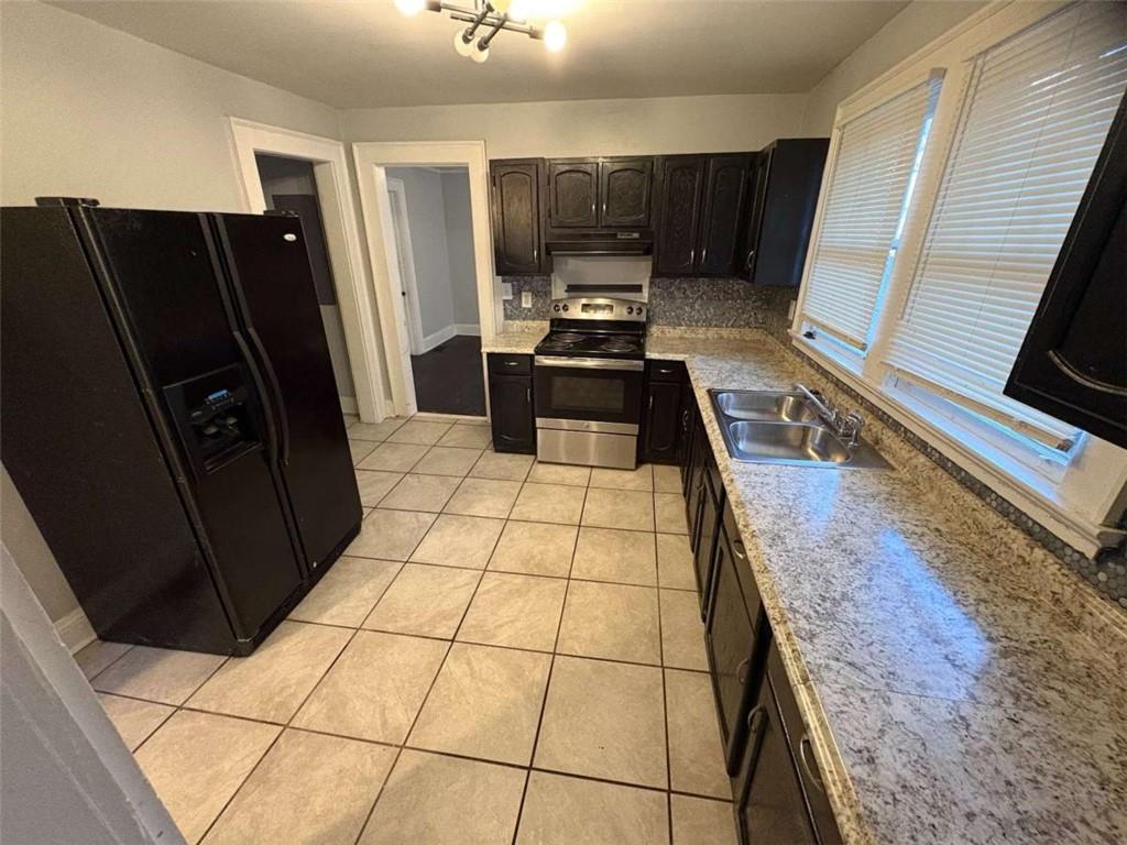 2421 Fairburn Road Southwest Atlanta, GA 30331 - Photo 14 of 15 a kitchen with granite countertop a refrigerator a stove and a sink