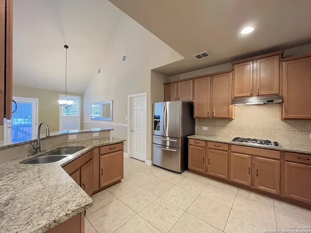 a kitchen with stainless steel appliances granite countertop a sink stove and refrigerator
