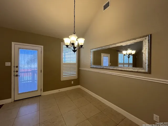 a view of a livingroom with a chandelier fan and windows