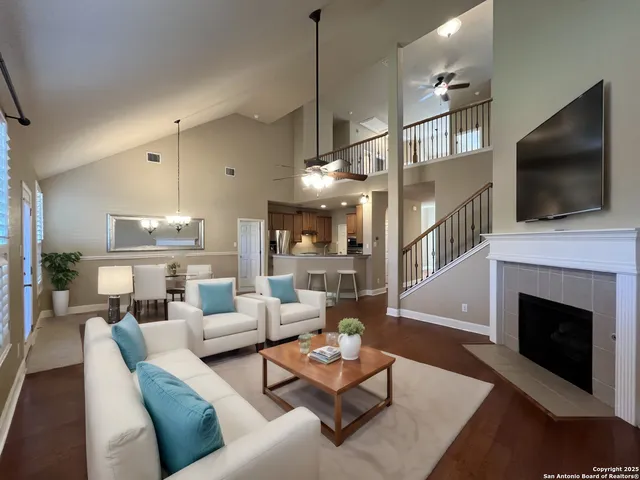 a living room with furniture a flat screen tv and a fireplace