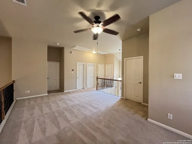 a view of an empty room with a ceiling fan