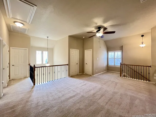 a view of a livingroom with a ceiling fan and windows