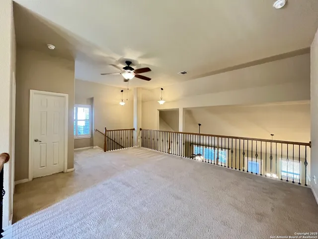 a view of a hallway with a ceiling fan